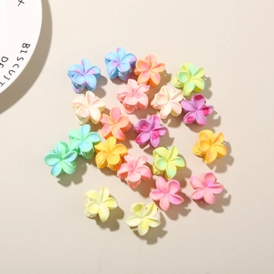 Vue à plat de mini pinces à cheveux fleur de frangipanier en résine marbrée