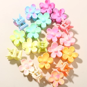 Flat lay of colorful 2.5cm flower hair claws in pastel resin with matte finish