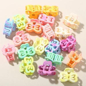Detail of colorful mini bow hair claws in macabre colors with gradient resin texture