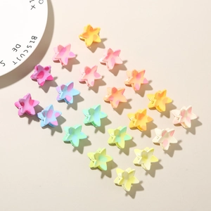Macro detail of star-shaped hair claws in colorful marble resin finish and pastel tones