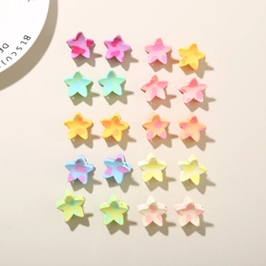 Flat lay of colorful star-shaped hair clips with marble texture on beige surface