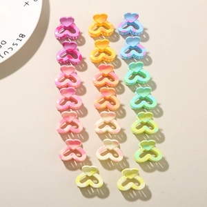 Macro detail of colorful heart-shaped mini hair claws in various vibrant macaron shades