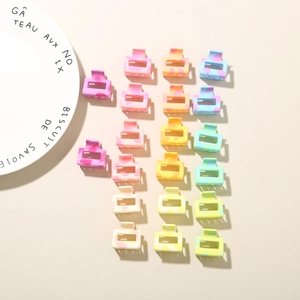 Macro shot of colorful 2.5cm mini plumeria hair claws in pastel gradient plastic finish