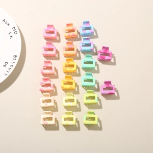 Detail view of colorful 2.5cm square hollow hair claws with cream speckled texture
