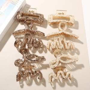 Macro view of ten acetate claw clips in marble brown and beige with minimalist props