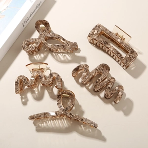 Detailed view of five amber marble acetate hair claws with premium metal springs