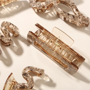 Detail view of coffee-colored marble pattern resin hair claws with metal spring mechanism