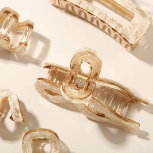Detailed close-up of marble pattern hair claws with sturdy gold metal springs