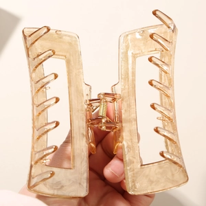 Detail view of large amber acetate hair claw clip with rectangle hollow design for thick hair