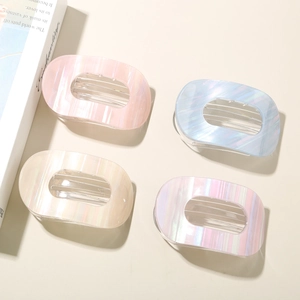Vue détaillée de quatre barrettes ovales nacrées en rose, bleu, doré et violet élégant