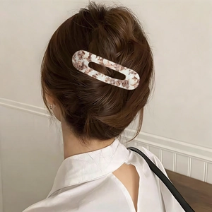 Close-up of a tortoiseshell acetate rectangle hair clip worn on a simple hair bun