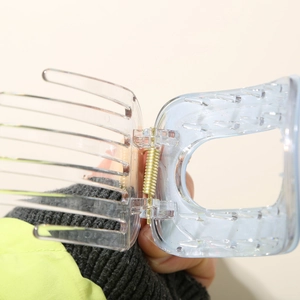 Détail de la pince à cheveux bleue et transparente avec ressort en métal doré et dents