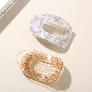 Close-up of marble pattern and amber acetate hair clips with metal spring mechanism