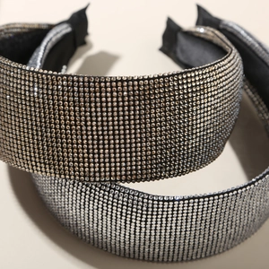 Gros plan détaillé du serre-tête large serti de strass brillants en couleurs or et argent