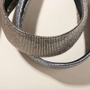 Détail de serre-tête large étincelant avec plusieurs rangées de strass argentés et base noire