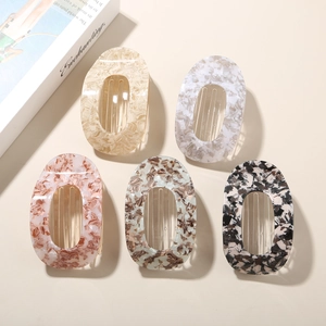 Flat round acetate hair clips in five assorted marble and tortoiseshell patterns