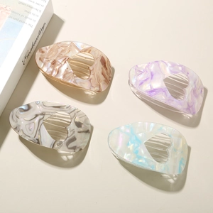 Detail view of heart-shaped acetate hair clips with marble texture in four colors