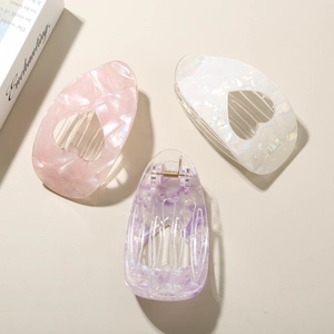 Three acetate heart-shaped hair clips with iridescent marble texture in pink, white, and purple