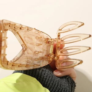 Macro shot of large heart-shaped amber cellulose acetate hair claw with gold metal spring