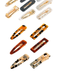 Gros plan de barrettes en acétate avec motifs marbrés et textures de feuilles d'or