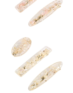 Détail de barrettes en acrylique effet marbre avec éclats de nacre rose et métal doré