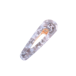 Detail view of marble pattern acetate hair clip with secure gold metal alligator clip