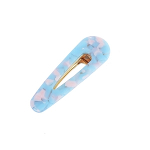 Detail of waterdrop acetate hair clip with blue and pink marble texture on gold metal