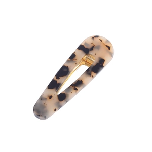 Detail of tortoise shell acetate hair clip with golden metal spring and leopard pattern