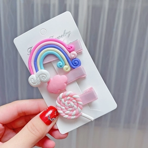 Close-up of cute rainbow and lollipop resin hair clips set for girls on display card