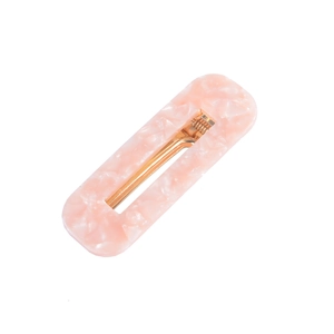 Detail of pink marble acetate hair clip with golden metal spring and acrylic texture