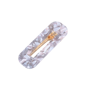 Detail view of the rectangular acetate hair clip with gray marble texture and gold metal clip