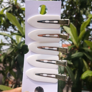Close-up of 5-piece white leaf-shaped seamless hair clips set on a display card