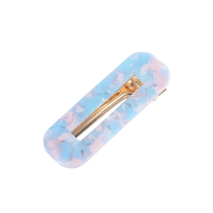 Detail of hollow rectangle hair clip with light blue and pink marble acetate texture