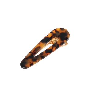 Detail of amber acetate hair clip with tortoiseshell pattern and gold metal duckbill clip
