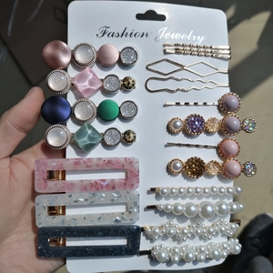 Détail de barrettes en acrylique effet marbre et bijoux en perles et strass sur carte