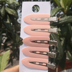 Close-up of five pink leaf-shaped seamless hair clips for makeup and styling