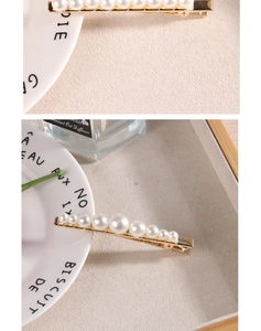 Détail d'une barrette à perles dégradées montée sur une pince en alliage doré