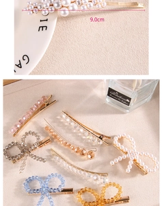 Détail de barrettes de 9cm en perles et cristaux sur fond de tissu chaleureux