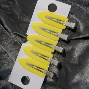 Detailed set of five yellow leaf-shaped hair clips on a white retail card display