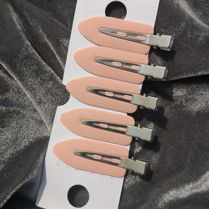 Set of 5 light pink creaseless leaf hair clips on white card over grey velvet fabric