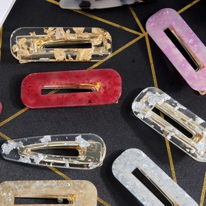 Fashionable acetate hair clips with amber resin and metallic foil flakes on gold metal bases