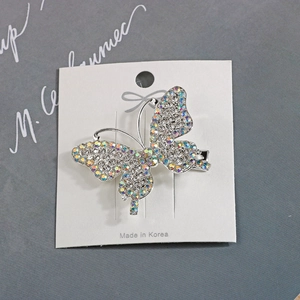 Elegant silver butterfly hair clip with colorful AB rhinestones on a display card
