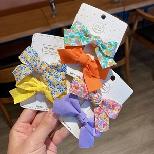 Five-piece bow hair clips set with solid colors and floral patterns on card