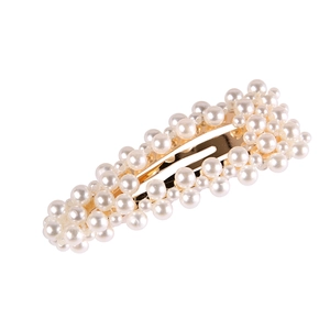 Pince à cheveux coréenne élégante en métal doré avec perles blanches sur fond blanc neutre