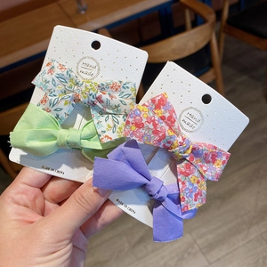 Handmade floral and solid color bow hair clips set on a display card for girls
