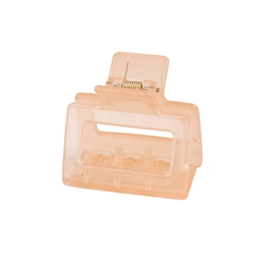 Detail view of pink translucent acrylic hair claw clip with golden metal spring and engraving