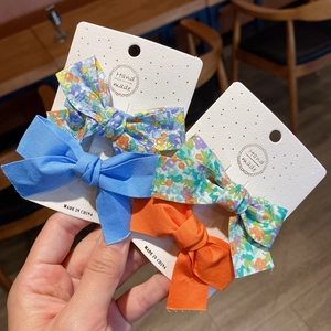 Two-piece floral and solid bow hair clip set for women and girls on handmade paper card