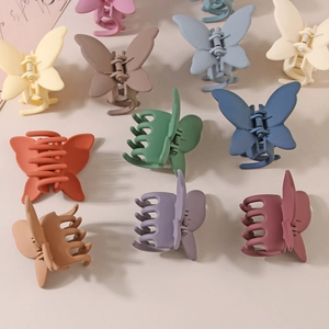 Détail de pinces à cheveux papillon mates aux couleurs Morandi avec ressort métallique