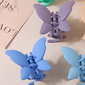 Détail de pinces à cheveux papillon au fini mat en plusieurs couleurs pastel macaron