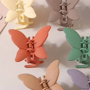 Détail de pinces à cheveux papillon mates colorées avec ressorts métalliques